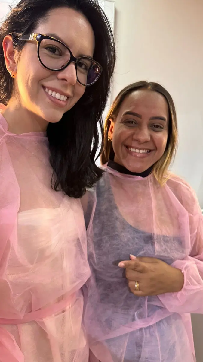 Profissional de saúde realizando o procedimento técnico na orelha de uma modelo durante o curso de furo de orelha humanizado em Belo Horizonte