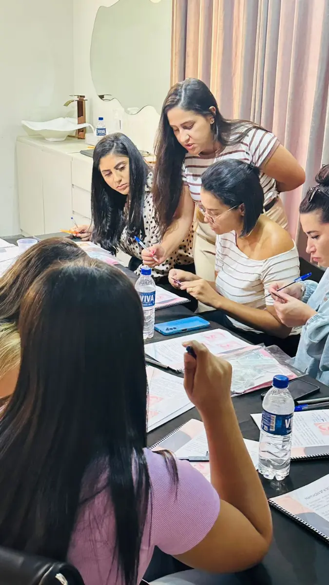 Aluna monitorada pela instrutora realizando a aplicação de brinco em modelo durante o furo humanizado curso presencial em Belo Horizonte